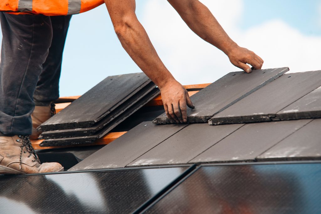 Man fixing and installing roofing.